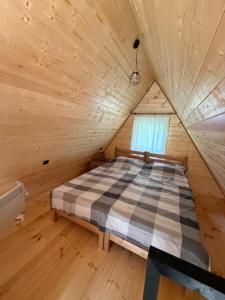 a bed in a wooden room with a window at Glola A-Frame Cottages in Glola