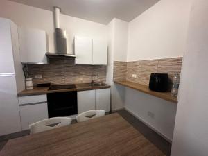 a kitchen with white cabinets and two toilets in it at sweet rest in Castel Maggiore