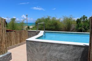 a swimming pool in a backyard with a fence at Bela Vista Japaratinga Flats e Temporada in Japaratinga