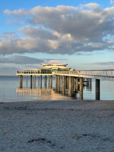 a pier on the beach with a building on it at Deck 8 in Timmendorfer Strand