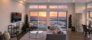 a living room with a couch and a balcony at Daniella's Suites in Peabody