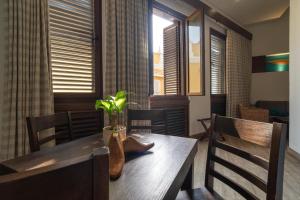 a dining room with a wooden table with a plant on it at Sophia Hotel By OxoHotel in Cartagena de Indias