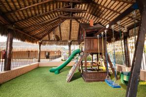 a playground with a slide and a swing at Marinaterra Hotel & Spa in San Carlos