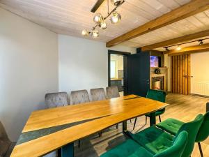 a dining room with a wooden table and green chairs at Шале in Krivopolʼye