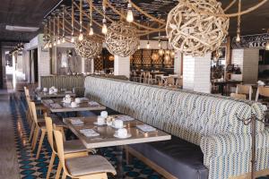 a dining room with tables and chairs and chandeliers at Marinaterra Hotel & Spa in San Carlos