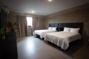 a hotel room with two beds and a window at Hotel Vista Alegre in Barranquitas
