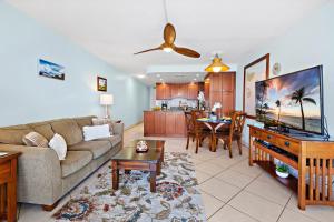 a living room with a couch and a flat screen tv at Kahana Reef 318 in Kahana