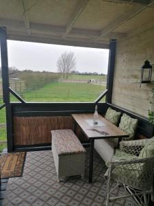 a screened in porch with a table and chairs at Theddlethorpe Horsebox Glamping in Theddlethorpe Saint Helen