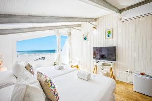 two beds in a room with a view of the ocean at Labreña Hotel in Los Caños de Meca