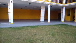 a large building with yellow walls and white columns at HOTEL REAL DEL MONTE WOODs in Mineral del Monte