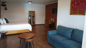 a room with a couch and a bed and a table at HOTEL REAL DEL MONTE WOODs in Mineral del Monte