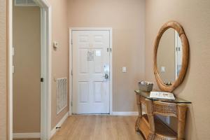 a hallway with a mirror and a table and a door at Bahama Bay Huge Penthouse condo in Kissimmee