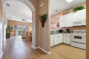 a kitchen with white cabinets and a living room at Bahama Bay Huge Penthouse condo in Kissimmee