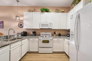 a kitchen with white cabinets and a white refrigerator at Bahama Bay Huge Penthouse condo in Kissimmee +30 photos