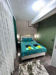 a bedroom with a bed with blue sheets and yellow pillows at Cataleya III in Sarajevo