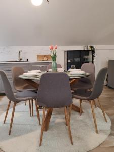 a dining room table with chairs and a vase of flowers at U prolazu in Đakovo +38 photos