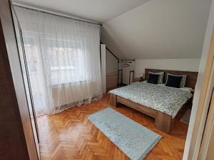 a bedroom with two beds and a window at U prolazu in Đakovo
