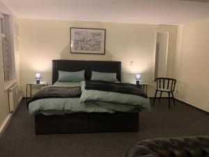 Ein Schlafzimmer mit einem großen Bett, zwei Tischen und zwei Lampen in der Unterkunft Ellerbach WG Komfortables Privatzimmer in Bad Kreuznach