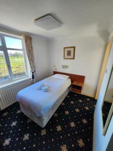 a bedroom with a bed and a large window at The Limes Hotel in Market Rasen