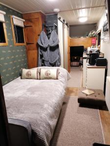 a bedroom with a bed and a desk in a room at Theddlethorpe Horsebox Glamping in Theddlethorpe Saint Helen +23 photos
