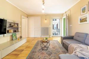 a living room with a couch and a tv at La Quiete del Mattino in Torre Pellice