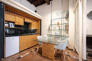 a kitchen with a glass table and white chairs at Vittoria Residence Spanish Steps in Rome