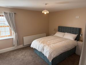 a bedroom with a large bed and a window at Dessie's in Magherasaul