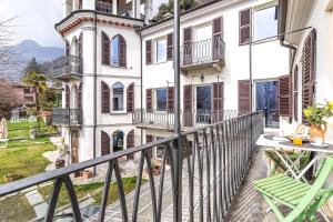 a balcony of a house with a green chair at La Quiete del Mattino in Torre Pellice