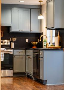 a kitchen with blue cabinets and a sink at Eden at Blue Lane in Olathe +39 photos