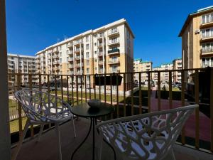 a balcony with two chairs and a table and a building at Kream Suite #Cosmopolis #Bucharest in Ştefăneştii de Sus +5 photos