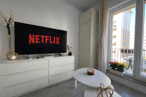 a living room with a television on a white dresser at Kream Suite #Cosmopolis #Bucharest in Ştefăneştii de Sus