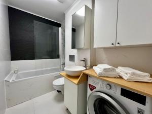 a bathroom with a washing machine and a sink at Kream Suite #Cosmopolis #Bucharest in Ştefăneştii de Sus