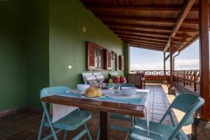 a dining room with a table and chairs on a balcony at El Cañaveral – Casa Rural con Terraza San Mateo in Vega de San Mateo