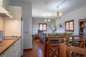 a kitchen and living room with a couch and a table at El Cañaveral – Casa Rural con Terraza San Mateo in Vega de San Mateo +22 photos