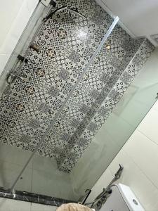 a glass shower in a bathroom with a tile floor at Lux Appartement Dahomy Beach in Bouznika +30 photos