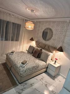 a bedroom with a large bed and a mirror at Lux Appartement Dahomy Beach in Bouznika