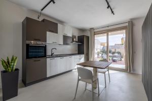 a kitchen with a table and chairs and a window at Relax Stay - Camere e Appartamenti con Giardino in Quartu Sant'Elena