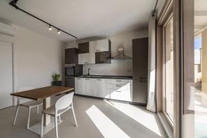 a kitchen with a wooden table and white cabinets at Relax Stay - Camere e Appartamenti con Giardino in Quartu Sant'Elena +30 photos