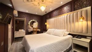 a bedroom with a white bed and a bathroom at Hotel Paris Carré in Valledupar +62 photos