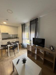 a living room with a table and a kitchen at LUGO Stay in Lugo