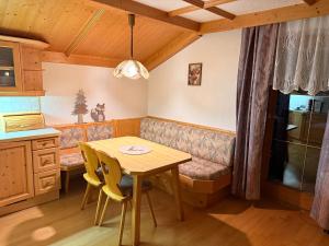 a kitchen with a wooden table and a couch at Haus Sauberbach in Jerzens