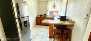 a kitchen with a refrigerator and a table with stools at Casa el Corral #2 in Aguacate