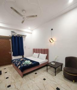 a bedroom with a bed and a couch and a chair at The Moksha Residency in Prayagraj