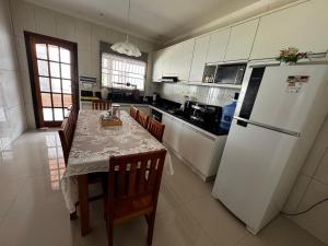 a kitchen with a table and a white refrigerator at Estrela de Euclides in Euclides da Cunha