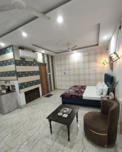 a bedroom with a bed and a chair and a table at The Moksha Residency in Prayagraj