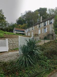 a house with a fence and a plant in front of it at Maison Avec Spa et Sauna Privé in Brive-la-Gaillarde