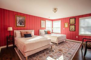 a bedroom with two beds and red walls at Eden at Blue Lane in Olathe