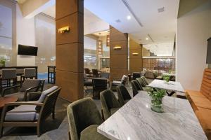 a restaurant with tables and chairs and a television at Crowne Plaza Villahermosa by IHG in Villahermosa