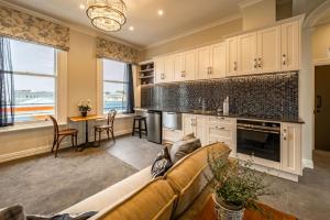 a living room with a couch and a kitchen with a table at The Empire Hotel in Timaru