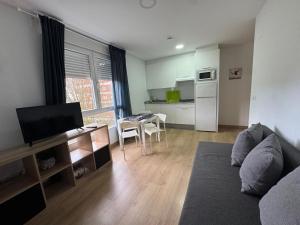 a living room with a couch and a table and a kitchen at LUGO Stay in Lugo